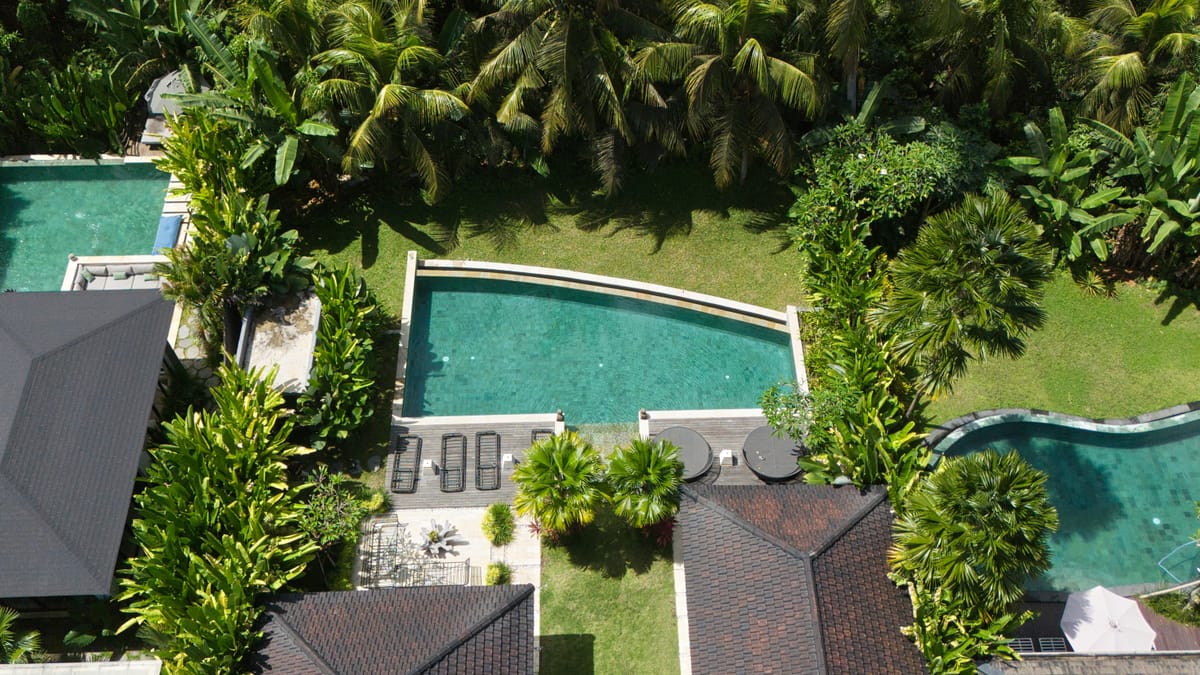 Aerial view of a private villa pool set within a tropical garden