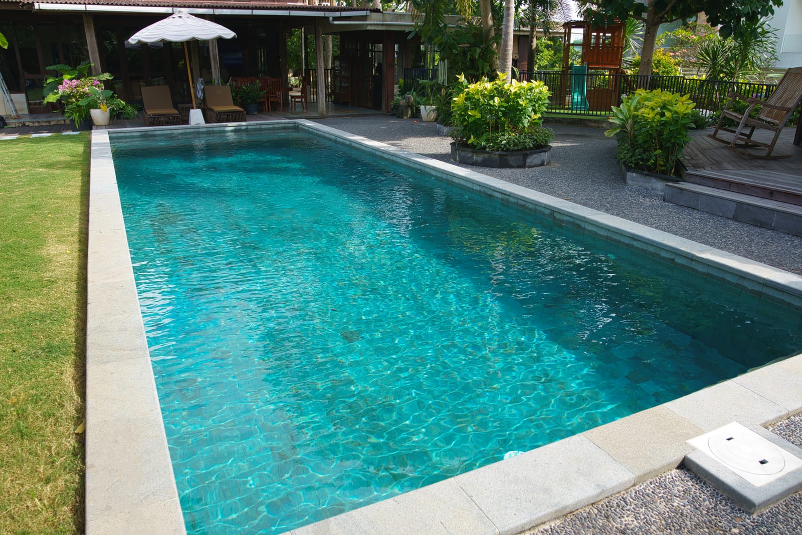 Turquoise villa pool with a timber pavilion and parasol