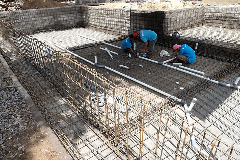Steel reinforcement and plumbing in place during pool shell construction
