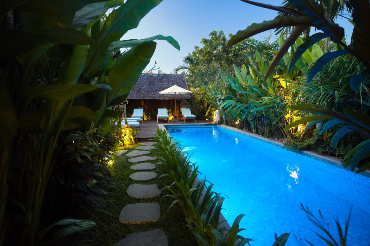 Villa pool and deck framed by jungle at The Woods, Uluwatu, Bali